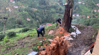 Rize'de heyelanda kayan toprağın önünü tıkadığı derede temizlik çalışması